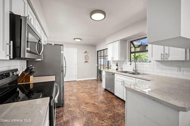 211 S Pinewood Dr, Post Falls, ID 83854 - kitchen with a sink, decorative backsplash, appliances with stainless steel finishes, and white cabinetry