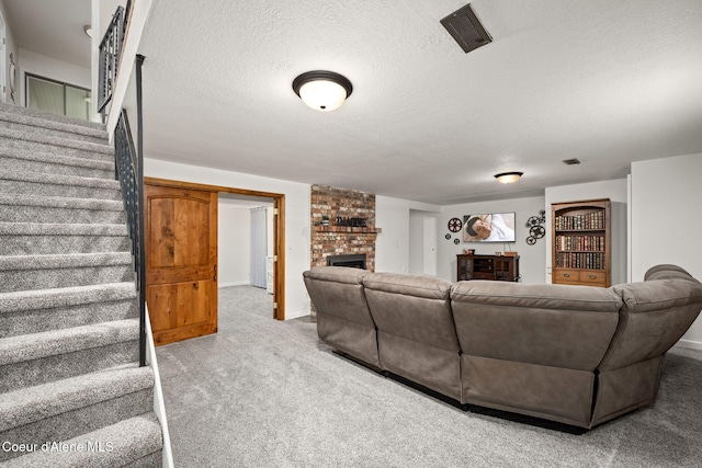 211 S Pinewood Dr, Post Falls, ID 83854 - living room with carpet flooring, a brick fireplace, a textured ceiling, visible vents, and stairway