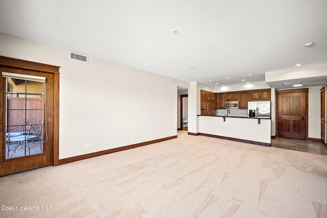 2151 N Main St # 226, Coeur Dalene, ID 83814 - unfurnished living room featuring baseboards, light colored carpet, recessed lighting, and visible vents