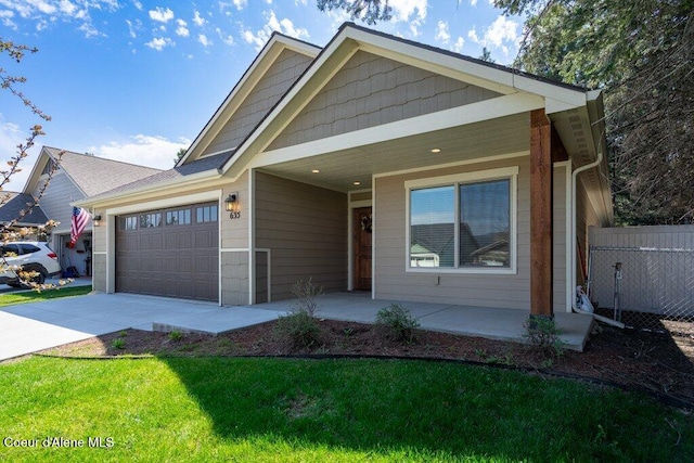 635 E Valley St, Oldtown, ID 83822 - view of front of property with covered porch, driveway, a front yard, a garage, and fence