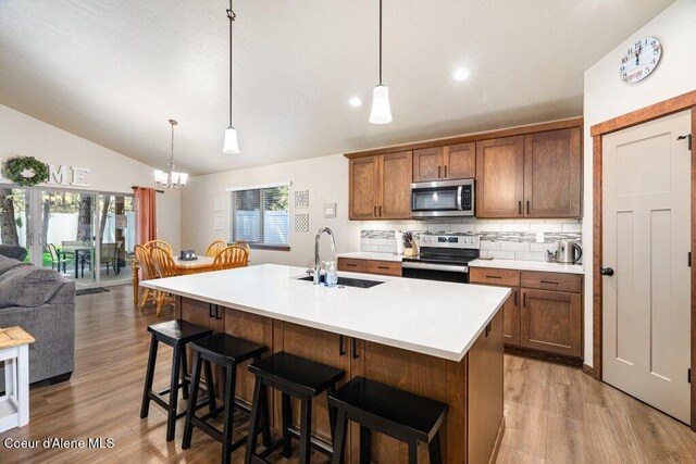 635 E Valley St, Oldtown, ID 83822 - kitchen featuring vaulted ceiling, wood finished floors, a sink, an inviting chandelier, and stainless steel appliances