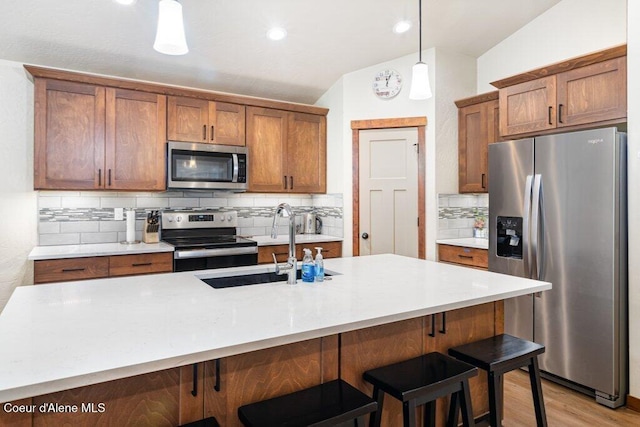 635 E Valley St, Oldtown, ID 83822 - kitchen with brown cabinetry, lofted ceiling, backsplash, and stainless steel appliances