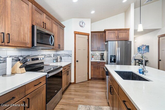 635 E Valley St, Oldtown, ID 83822 - kitchen with brown cabinets, appliances with stainless steel finishes, a sink, light wood-style floors, and tasteful backsplash