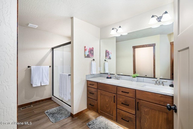 635 E Valley St, Oldtown, ID 83822 - full bath featuring a stall shower, visible vents, a sink, and wood finished floors