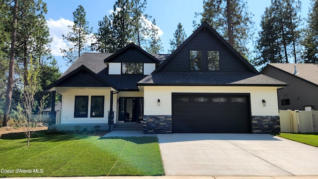 craftsman-style home featuring roof with shingles, fence, driveway, and a front lawn