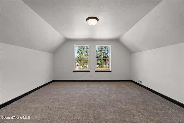 bonus room with carpet flooring, a textured ceiling, baseboards, and lofted ceiling
