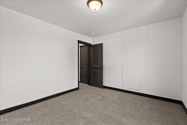 spare room with baseboards and carpet