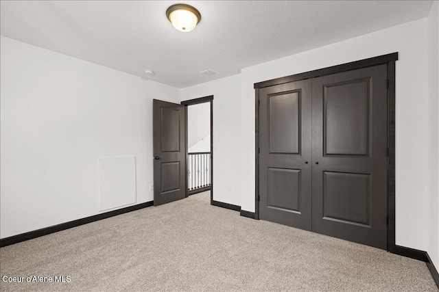 unfurnished bedroom with baseboards, carpet, and a closet