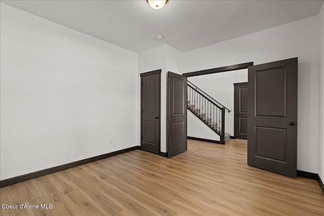 interior space with stairway, baseboards, and light wood-type flooring