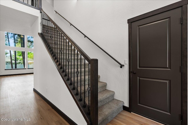 staircase with baseboards and wood finished floors