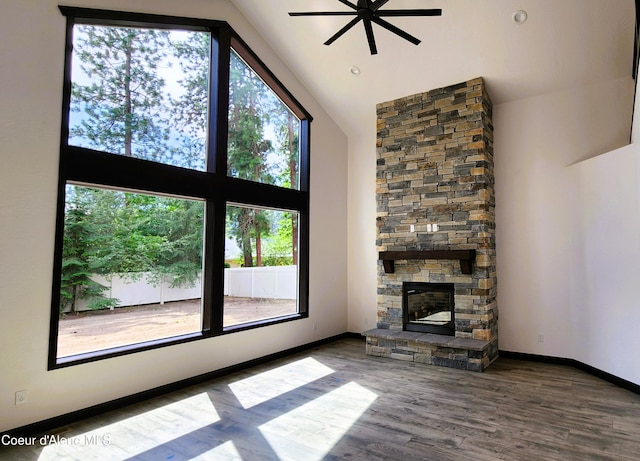 unfurnished living room featuring wood finished floors, a fireplace, baseboards, ceiling fan, and high vaulted ceiling