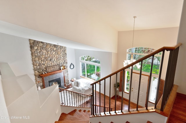 8533 N Tartan Dr, Hayden, ID 83835 - stairs featuring wood finished floors, a high ceiling, a stone fireplace, and baseboards