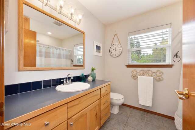 8533 N Tartan Dr, Hayden, ID 83835 - bathroom featuring healthy amount of natural light, vanity, toilet, and tile patterned floors