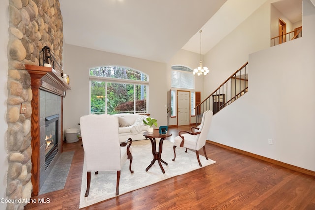 8533 N Tartan Dr, Hayden, ID 83835 - living room with a large fireplace, wood finished floors, high vaulted ceiling, a chandelier, and stairway