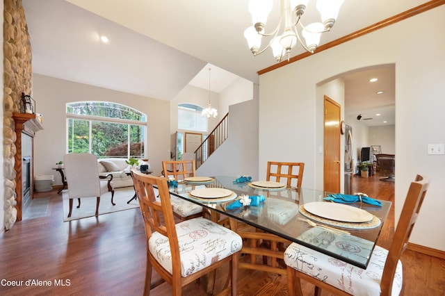 8533 N Tartan Dr, Hayden, ID 83835 - dining area with a chandelier, arched walkways, wood finished floors, baseboards, and a fireplace
