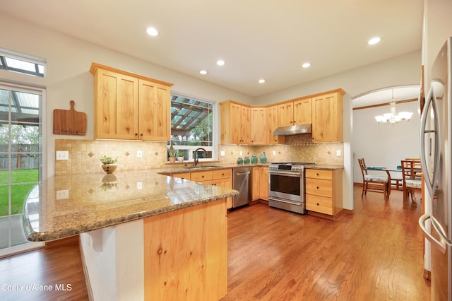 8533 N Tartan Dr, Hayden, ID 83835 - kitchen featuring stainless steel appliances, light brown cabinetry, under cabinet range hood, a peninsula, and recessed lighting