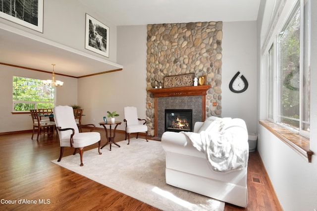 8533 N Tartan Dr, Hayden, ID 83835 - living area with a chandelier, wood finished floors, a stone fireplace, and baseboards