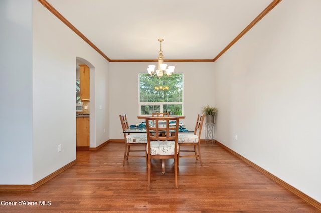 8533 N Tartan Dr, Hayden, ID 83835 - dining space featuring arched walkways, light wood-style flooring, a chandelier, crown molding, and baseboards