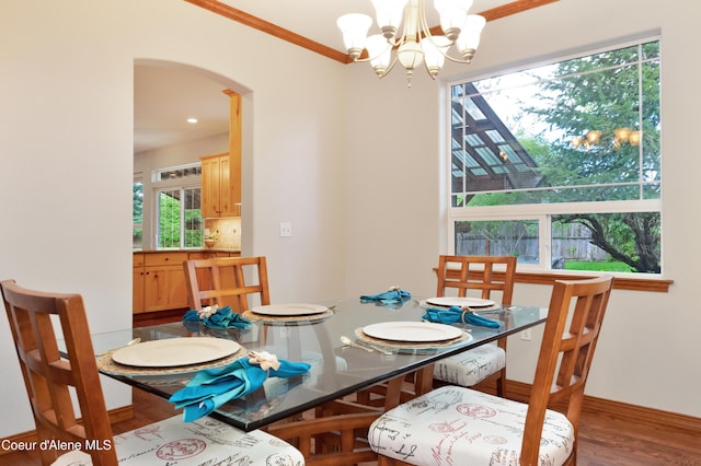 8533 N Tartan Dr, Hayden, ID 83835 - dining space featuring arched walkways, wood finished floors, a chandelier, crown molding, and baseboards