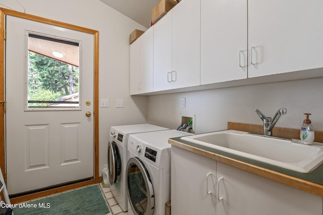 washroom featuring separate washer and dryer, a sink, and cabinet space