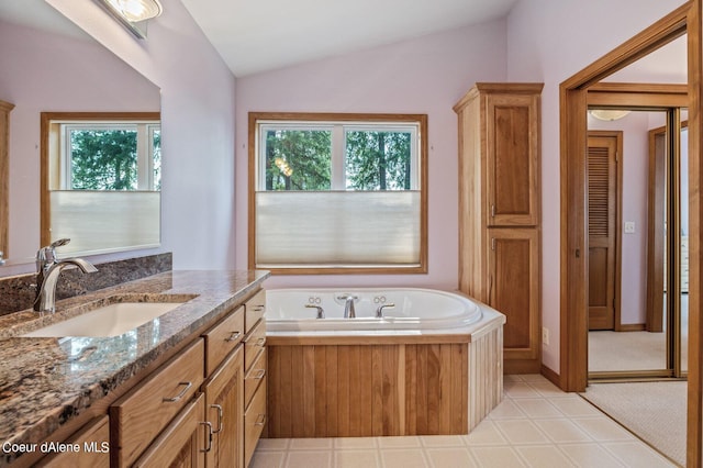 full bathroom featuring vanity, a bath, vaulted ceiling, and a wealth of natural light