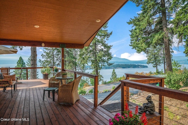 wooden terrace featuring a water and mountain view