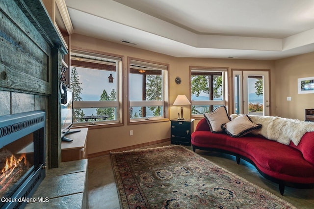 living area featuring baseboards, visible vents, and a fireplace