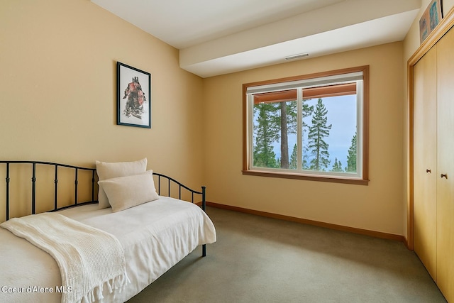 bedroom featuring baseboards, carpet, visible vents, and a closet