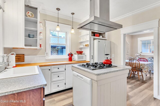706 Main St, Sandpoint, ID 83864 - kitchen featuring open shelves, ornamental molding, white appliances, island exhaust hood, and a sink