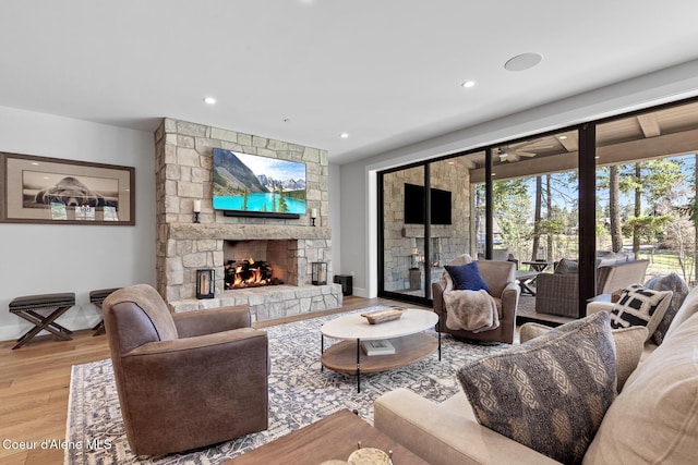 living area featuring baseboards, a fireplace, recessed lighting, and wood finished floors