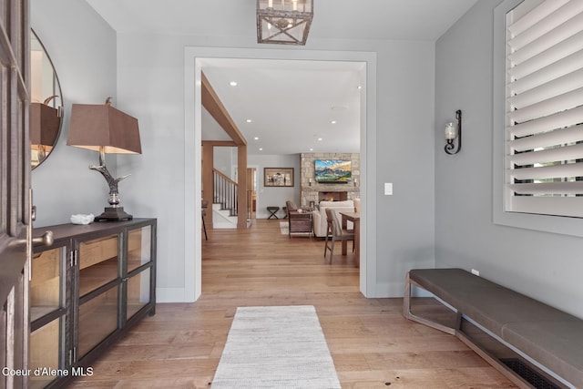 interior space featuring recessed lighting, baseboards, light wood finished floors, and stairs