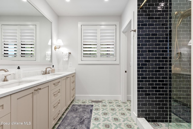bathroom with a sink, double vanity, and tiled shower
