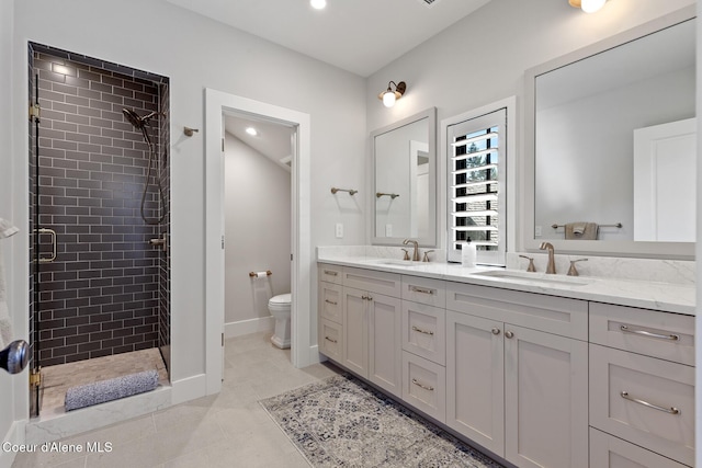 full bathroom featuring double vanity, toilet, a sink, and a stall shower