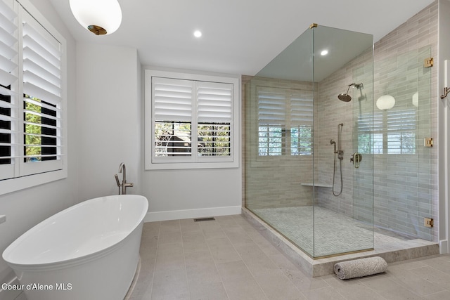 full bath with visible vents, tile patterned floors, a freestanding bath, and a stall shower