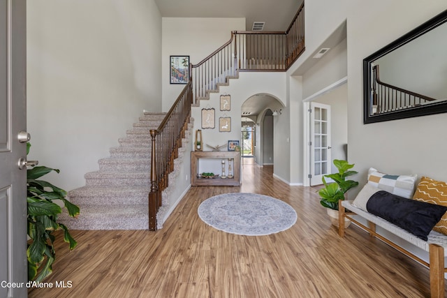 9362 N Prince William Loop, Hayden, ID 83835 - entryway with arched walkways, stairs, wood finished floors, a towering ceiling, and baseboards