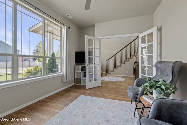 9362 N Prince William Loop, Hayden, ID 83835 - living area featuring french doors, baseboards, wood finished floors, stairway, and a ceiling fan