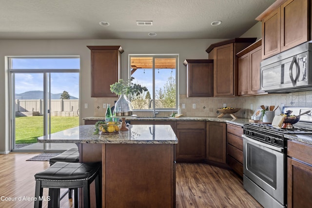 9362 N Prince William Loop, Hayden, ID 83835 - kitchen featuring stainless steel appliances, a sink, dark wood-style flooring, light stone counters, and recessed lighting