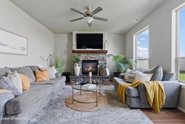 9362 N Prince William Loop, Hayden, ID 83835 - living area featuring wood finished floors, healthy amount of natural light, a ceiling fan, and a fireplace