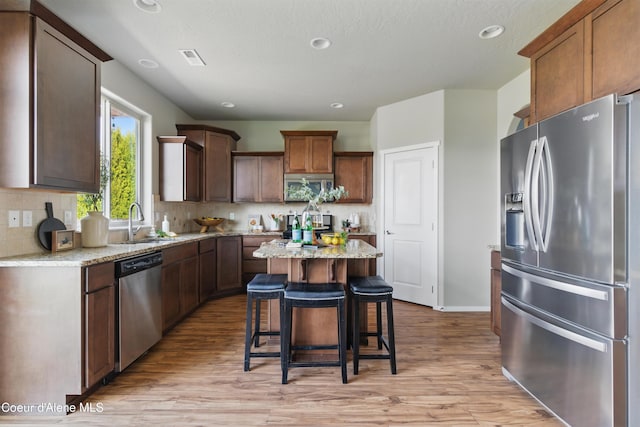 9362 N Prince William Loop, Hayden, ID 83835 - kitchen with stainless steel appliances, a sink, light wood-style floors, tasteful backsplash, and recessed lighting