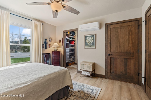 17 Hitchcock Dr, Dover, ID 83825 - bedroom with an AC wall unit, light wood-type flooring, a ceiling fan, a spacious closet, and a closet