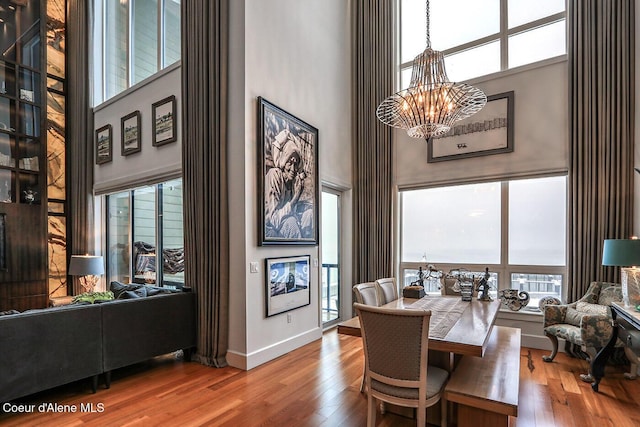 412 Sandpoint Ave Unit 332, Sandpoint, ID 83864 - dining room with baseboards, a high ceiling, wood finished floors, and a chandelier
