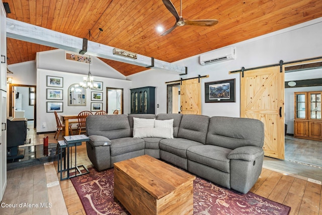 living room featuring a wall mounted AC, a barn door, ceiling fan with notable chandelier, vaulted ceiling with beams, and hardwood / wood-style floors