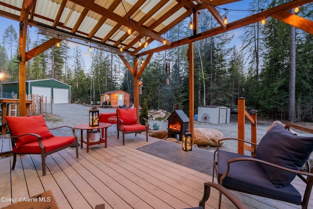 wooden deck with a storage unit, an outdoor structure, and a detached garage