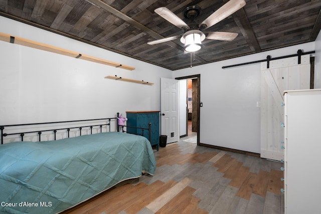 bedroom with hardwood / wood-style floors, baseboards, wood ceiling, and a barn door