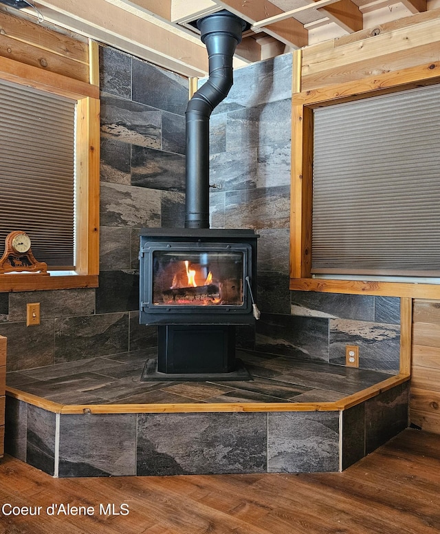 interior details with wood finished floors and a wood stove