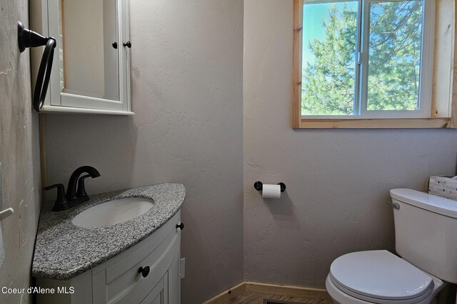 half bath featuring toilet and vanity