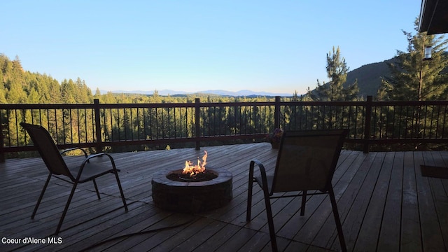 deck featuring a mountain view and an outdoor fire pit