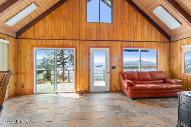 living room with wooden walls, wood ceiling, high vaulted ceiling, and beam ceiling
