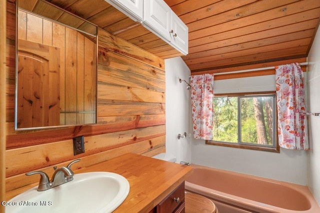 full bathroom featuring vanity, wood walls, toilet, a bath, and wooden ceiling