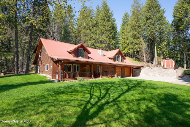 2264 Parker Canyon Rd, Bonners Ferry, ID 83805 - back of house with covered porch, a garage, an outdoor structure, a storage unit, and a yard
